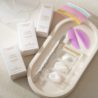 Eyelash extension kit with tools and packaging on a neutral background from The London Brow Company